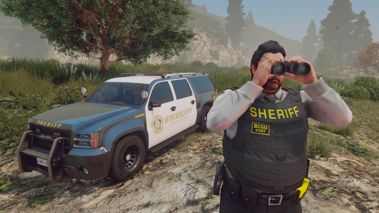 Rooster Craw, a FiveM ped in a sheriff vest, scans the hills through binoculars beside a marked sheriff SUV