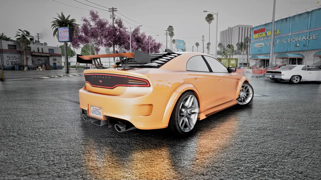 Buffalo TTX rear three-quarter view in orange with a raised rear wing on a rainy street by a storage building