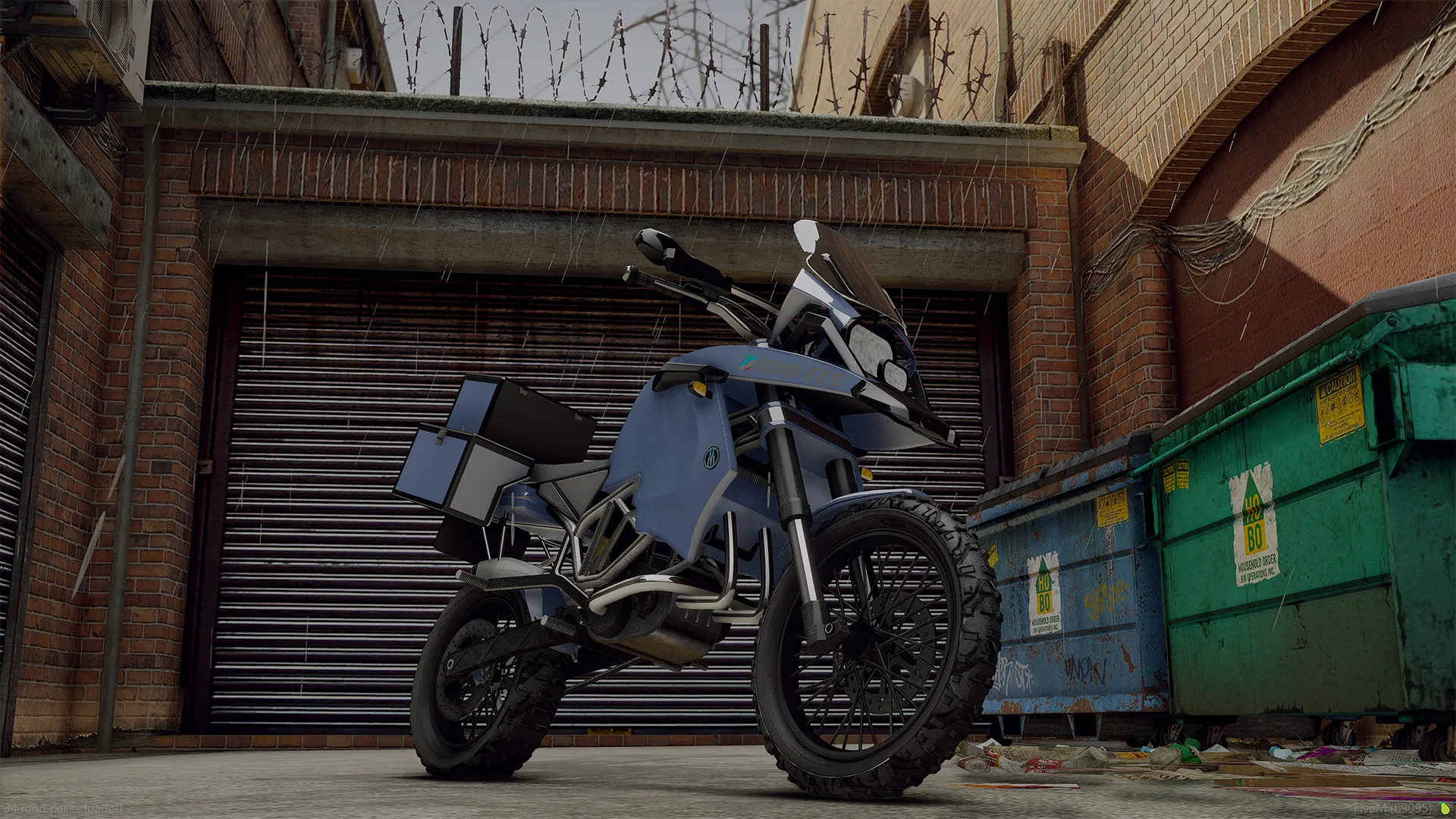 Ubermacht 1130 TTS front three-quarter view in blue with rugged tires by a shutter door and dumpsters
