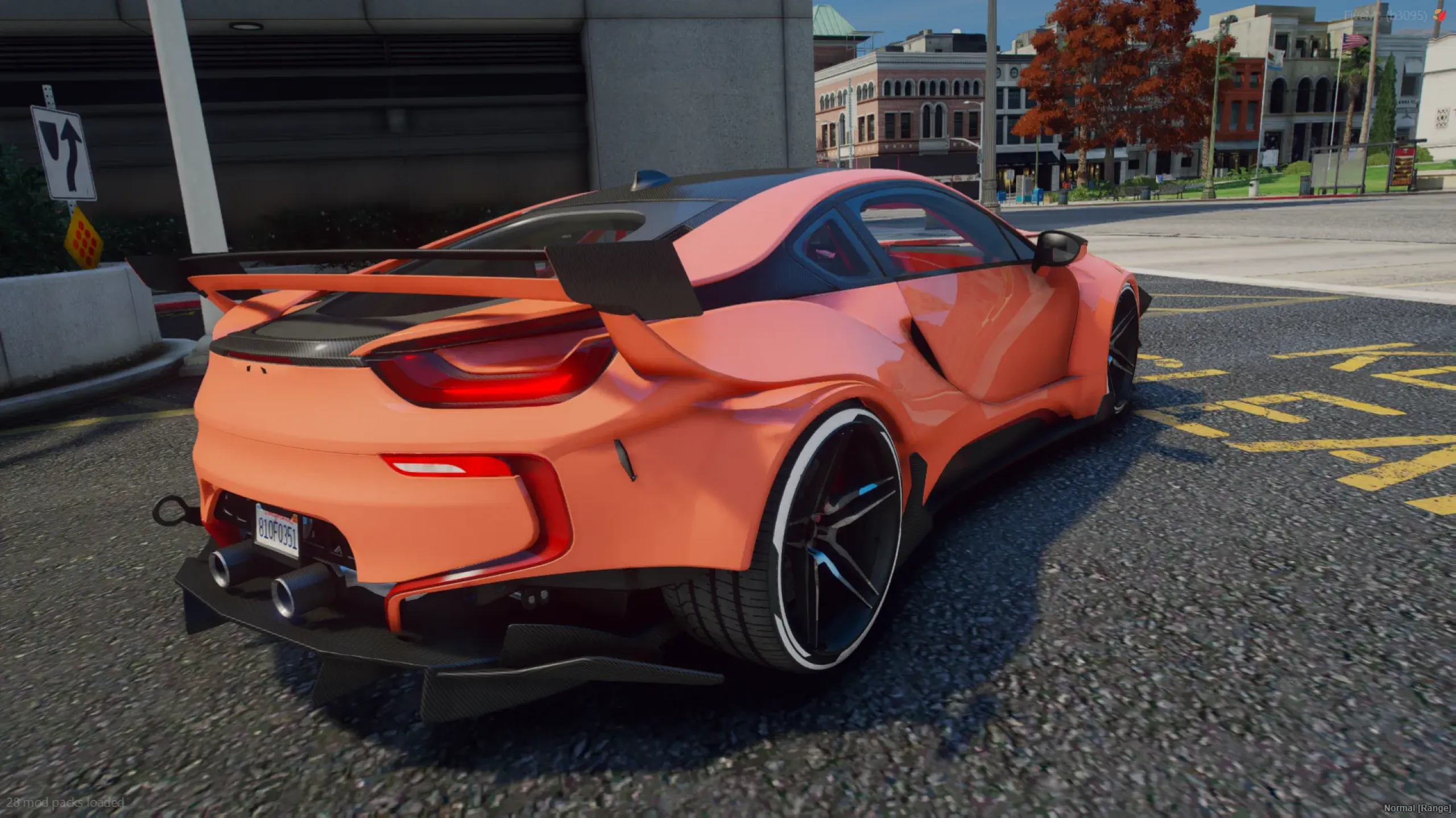 BMW i8 Custom Edition rear three-quarter with a large rear wing and dual exhausts on a city street