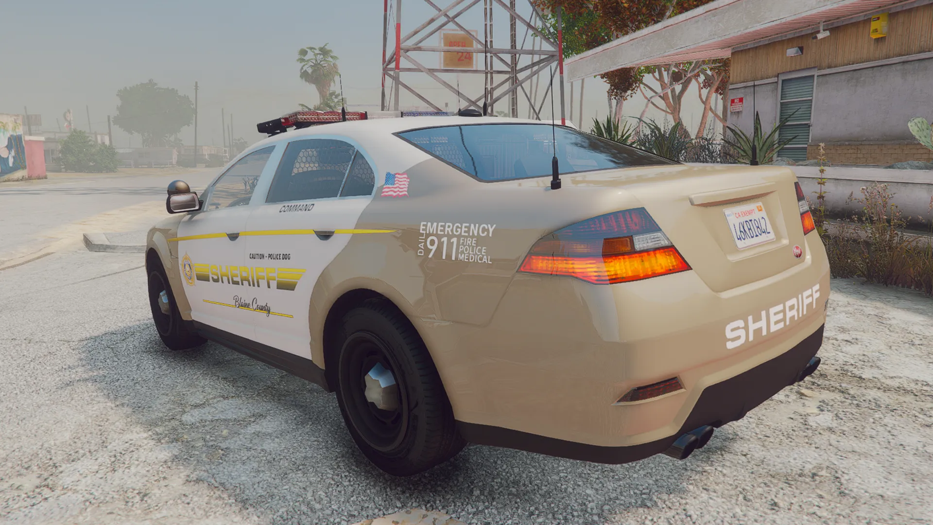 Police Cruiser V1 in tan and white Sheriff livery, rear three-quarter on a hazy small town street in FiveM