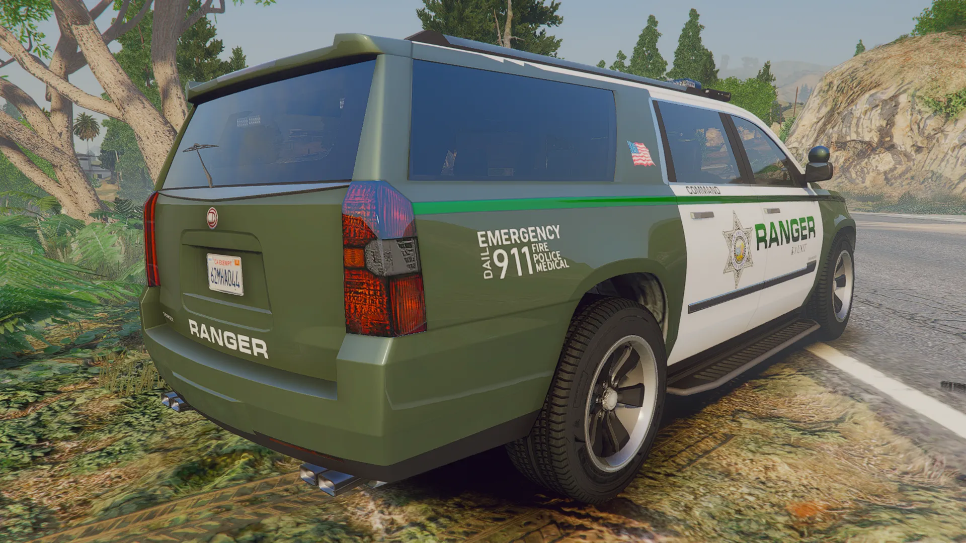 Police Granger V1 in olive green and white Ranger livery, rear three-quarter view on a forest road