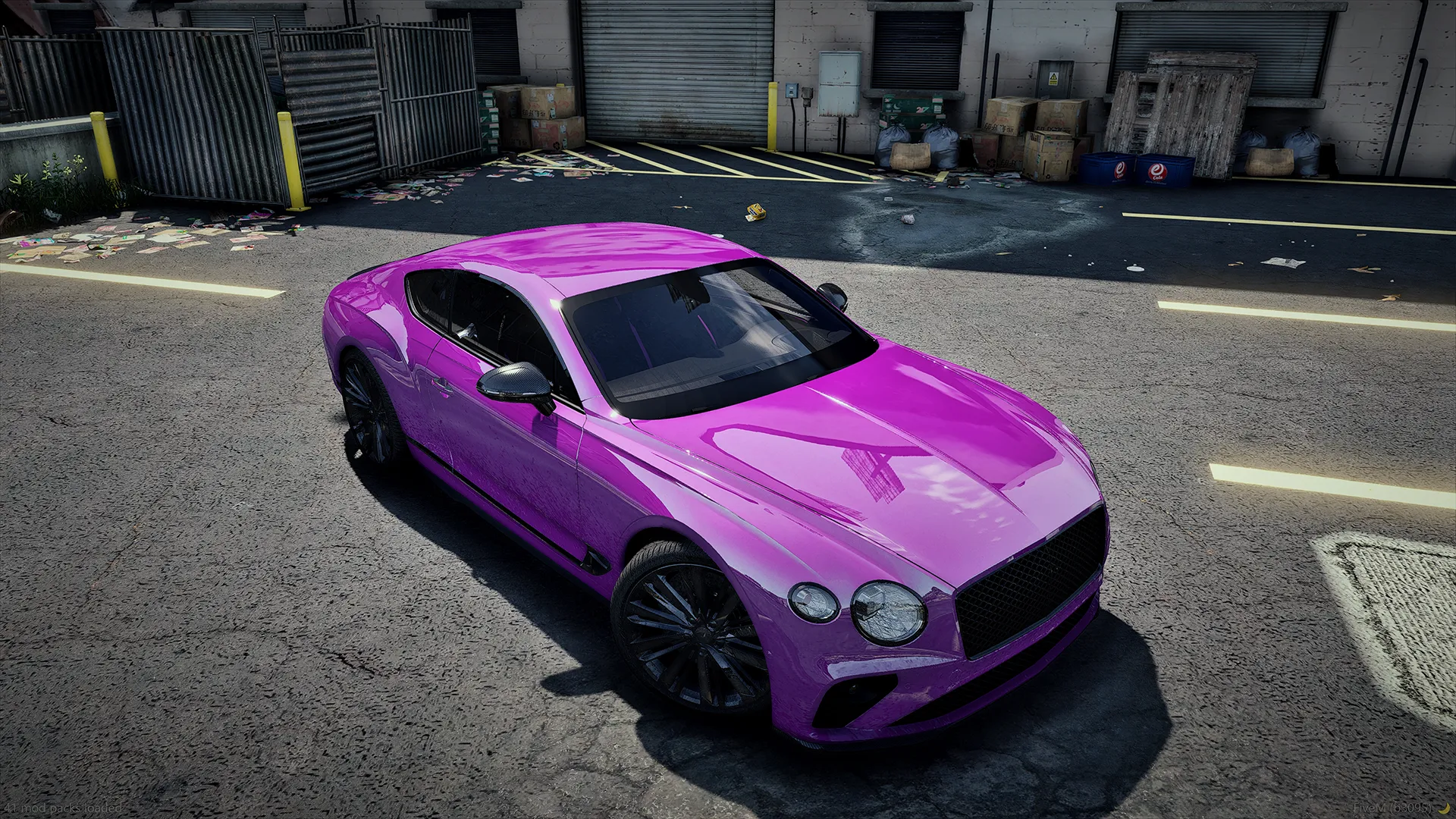 Bentley Continental GT in magenta with black wheels seen from an elevated front angle in a warehouse lot