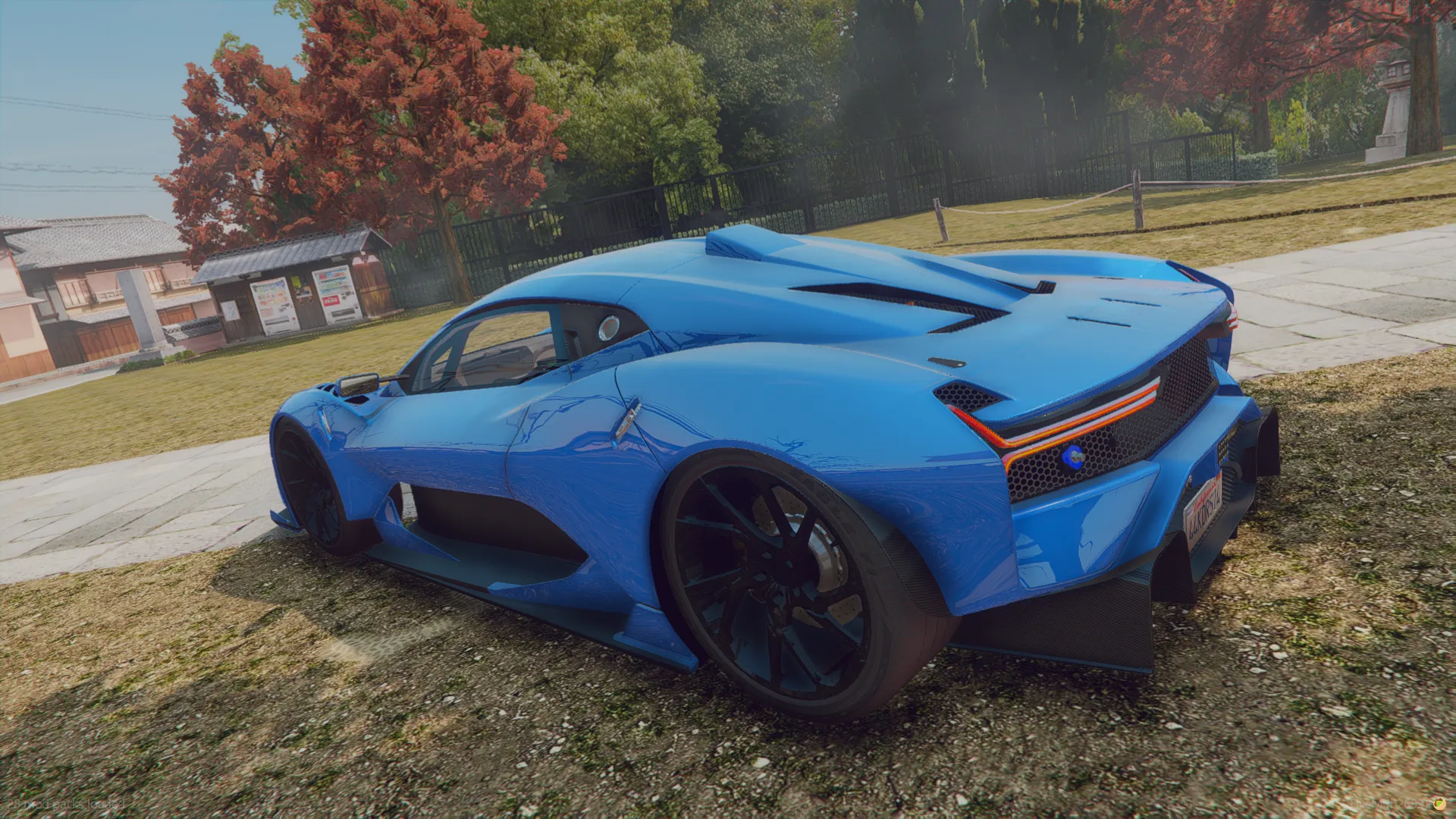 Brabham BT62 2018 rear three-quarter view in blue with orange-trimmed taillights and carbon diffuser on a lawn