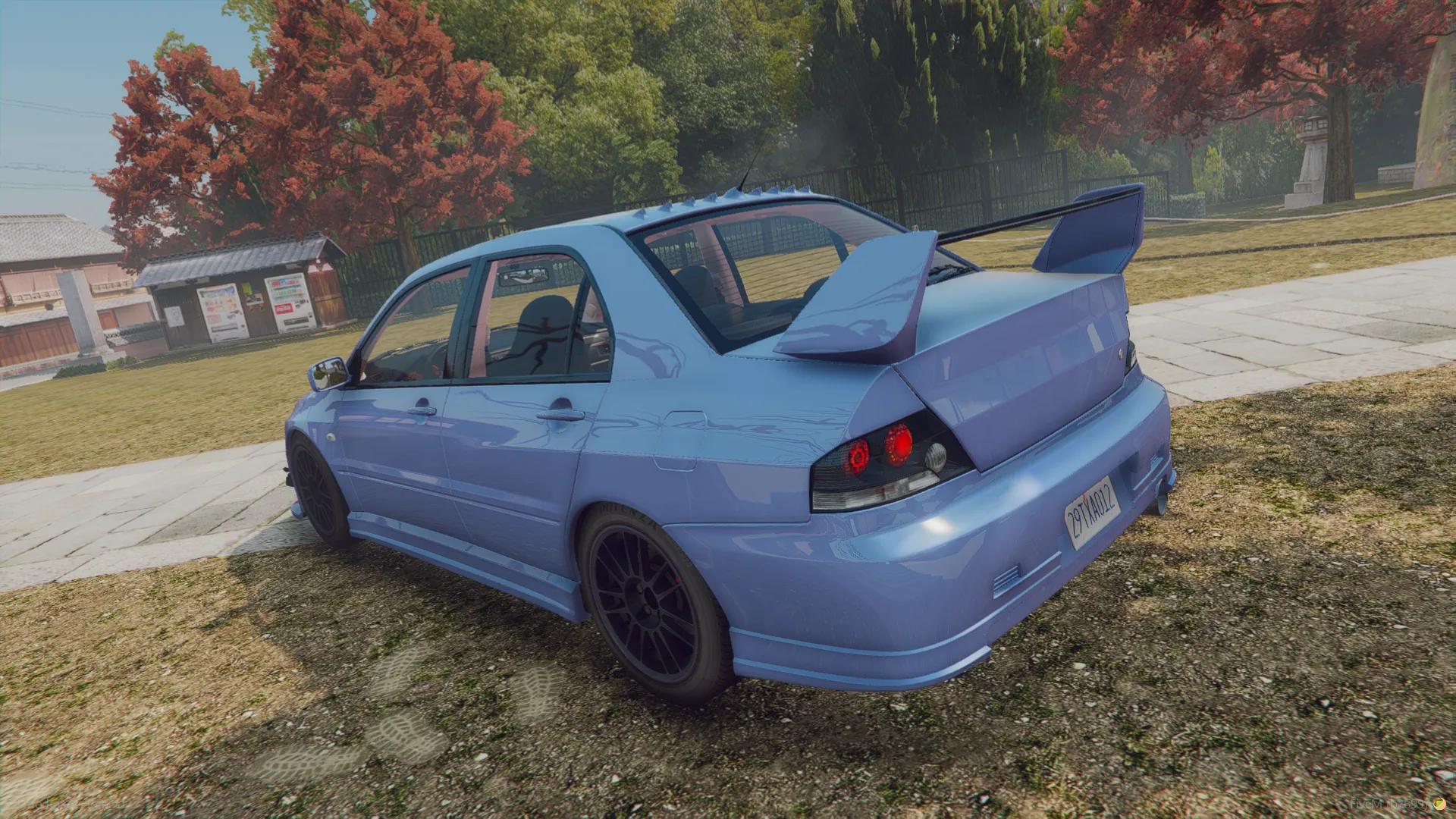 Mitsubishi Lancer Evo IX MR 2006 rear three-quarter view in pale blue with twin-plane rear wing parked on grass