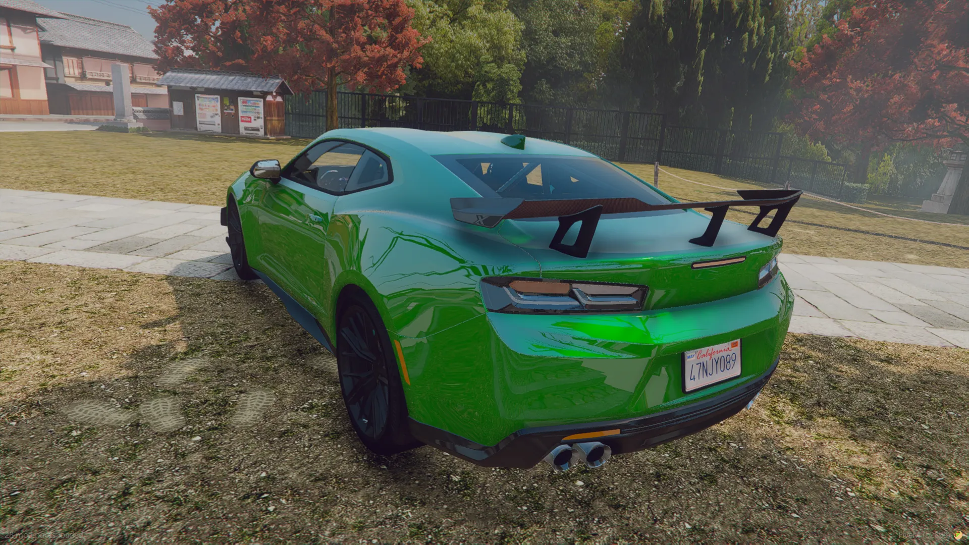 Chevrolet Camaro ZL1 2022 rear three-quarter view in green with a black rear wing and twin exhausts on a lawn