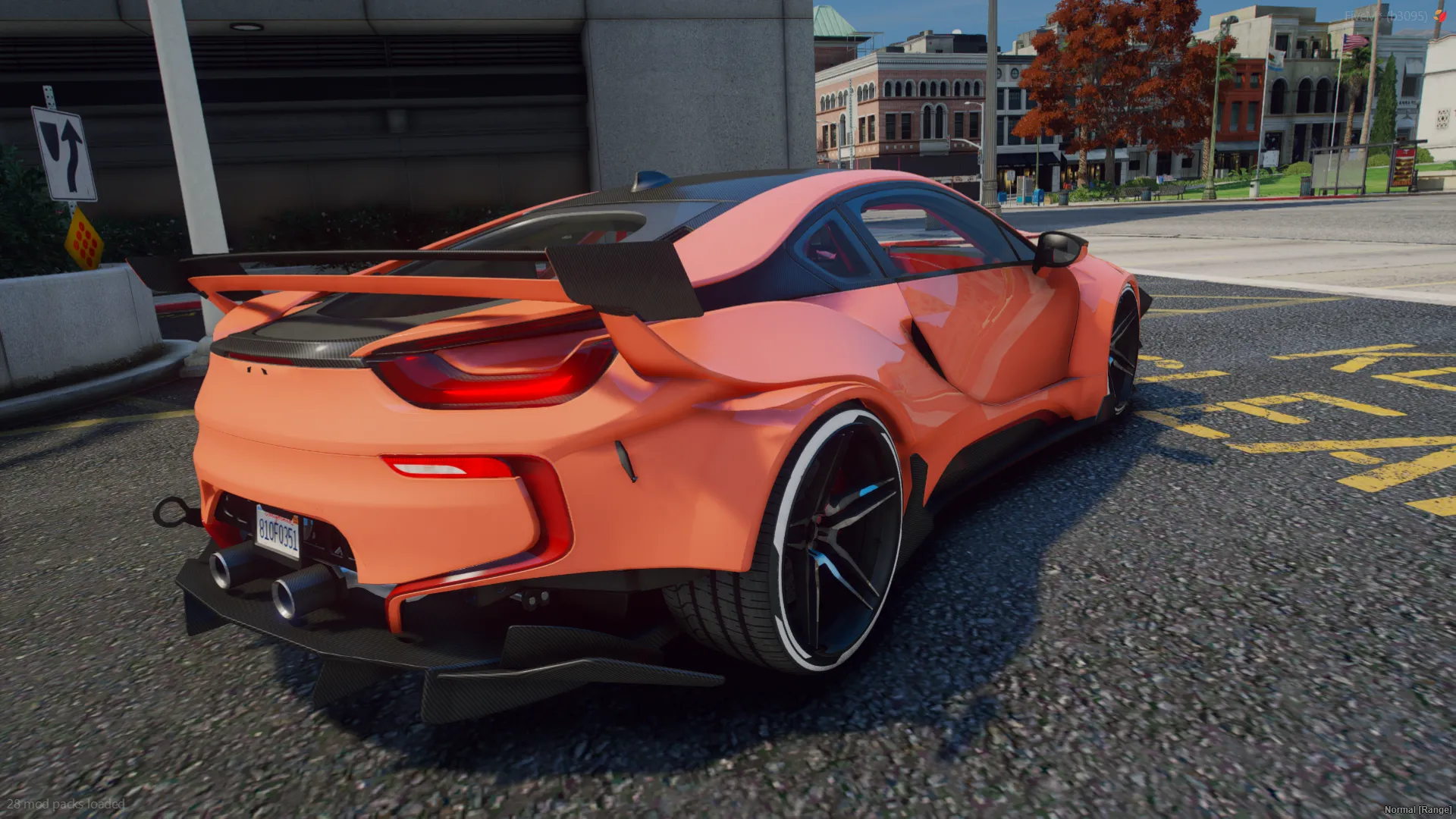 BMW i8 Custom Edition rear three-quarter view in orange with a large black rear wing and twin exhausts
