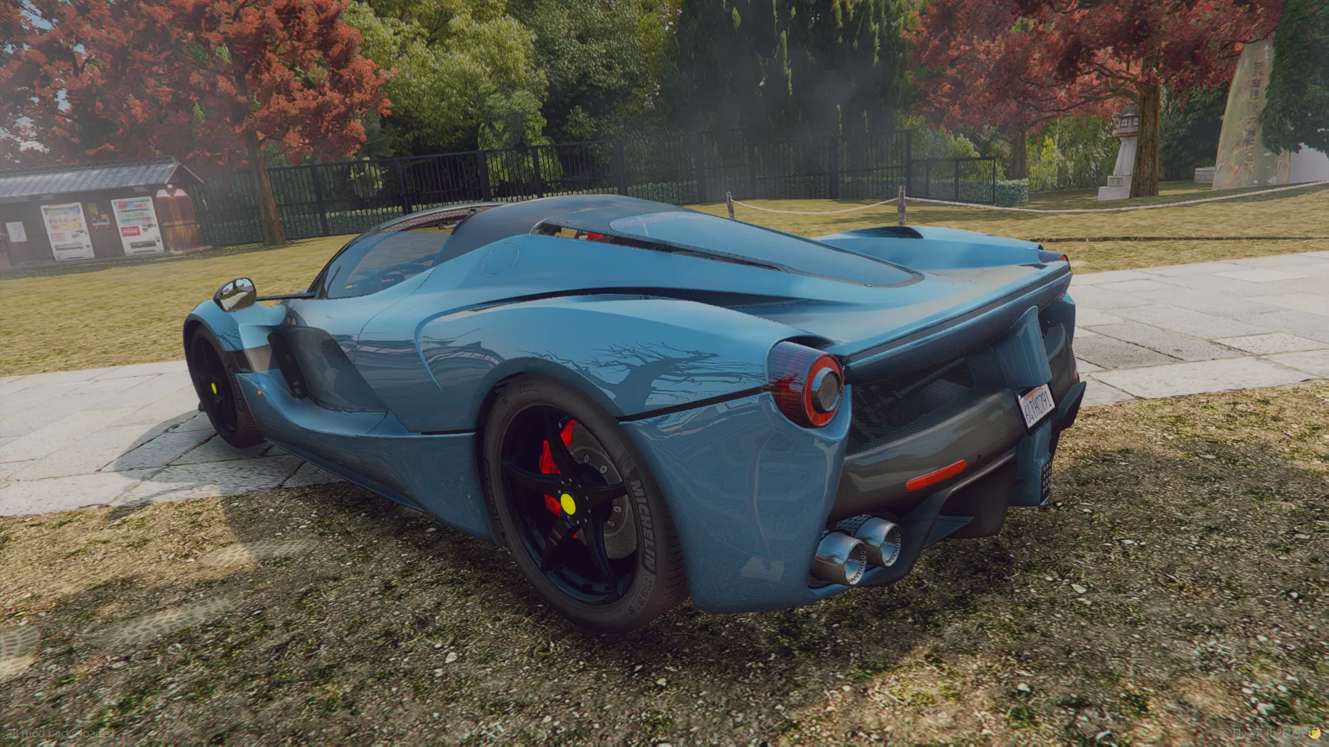 Ferrari LaFerrari 2013 rear three-quarter view in steel blue with triple exhausts and black wheels on grass