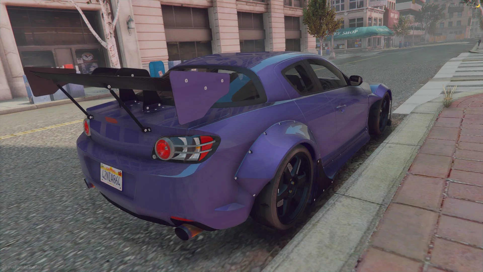 Mazda RX8 Bodykit 2002 rear three-quarter view with tall rear wing and riveted fender flares at a curb